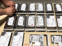 Screenshot of Identification of damaged hard drives from a failed RAID system during viability analysis service, clearly marked with red tags to isolate and prioritize faulty components. This precise identification enables focused recovery efforts on operational drives, ensuring data integrity and maximizing the chances of successful restoration in complex storage environments.